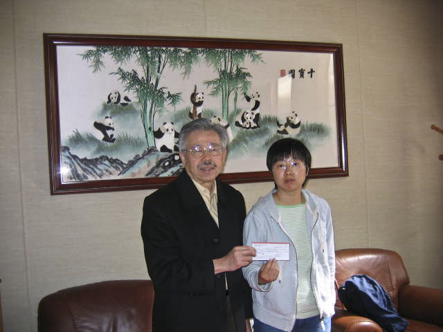 Stan Liou handing a $1,700 check to a Chinese Consulate personnel