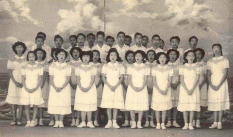 Boys and girls singing together at a school concert in 1953