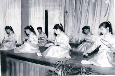 Wan Hua girls showing sewing skills on stage